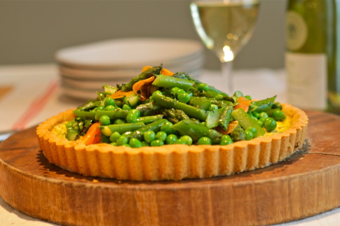 Herbed ricotta cheese tart topped with spring vegetables and an almond (gluten free) crust